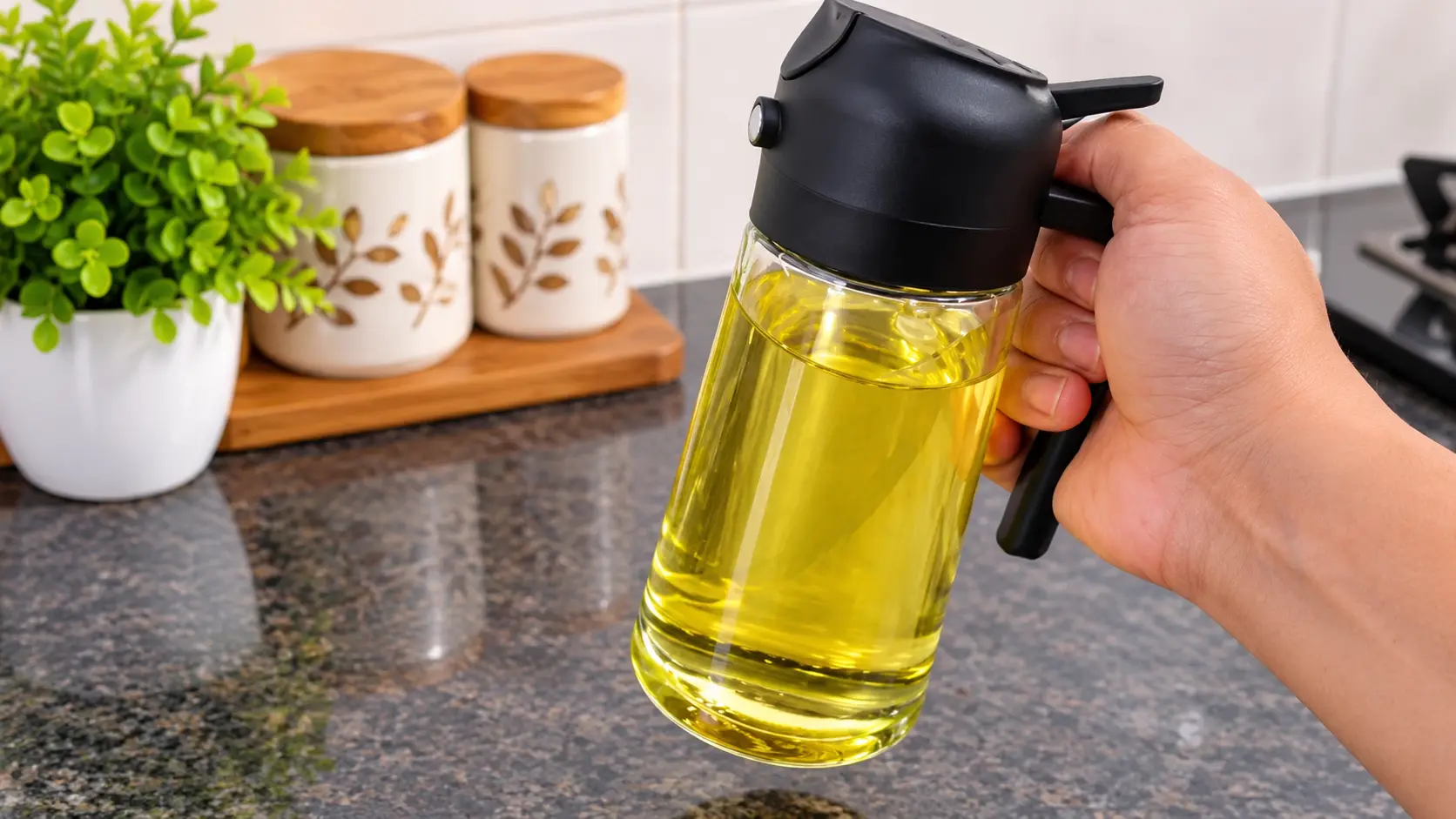 Pigeon glass oil sprayer and dispenser bottle 450ml black held by hand in a kitchen